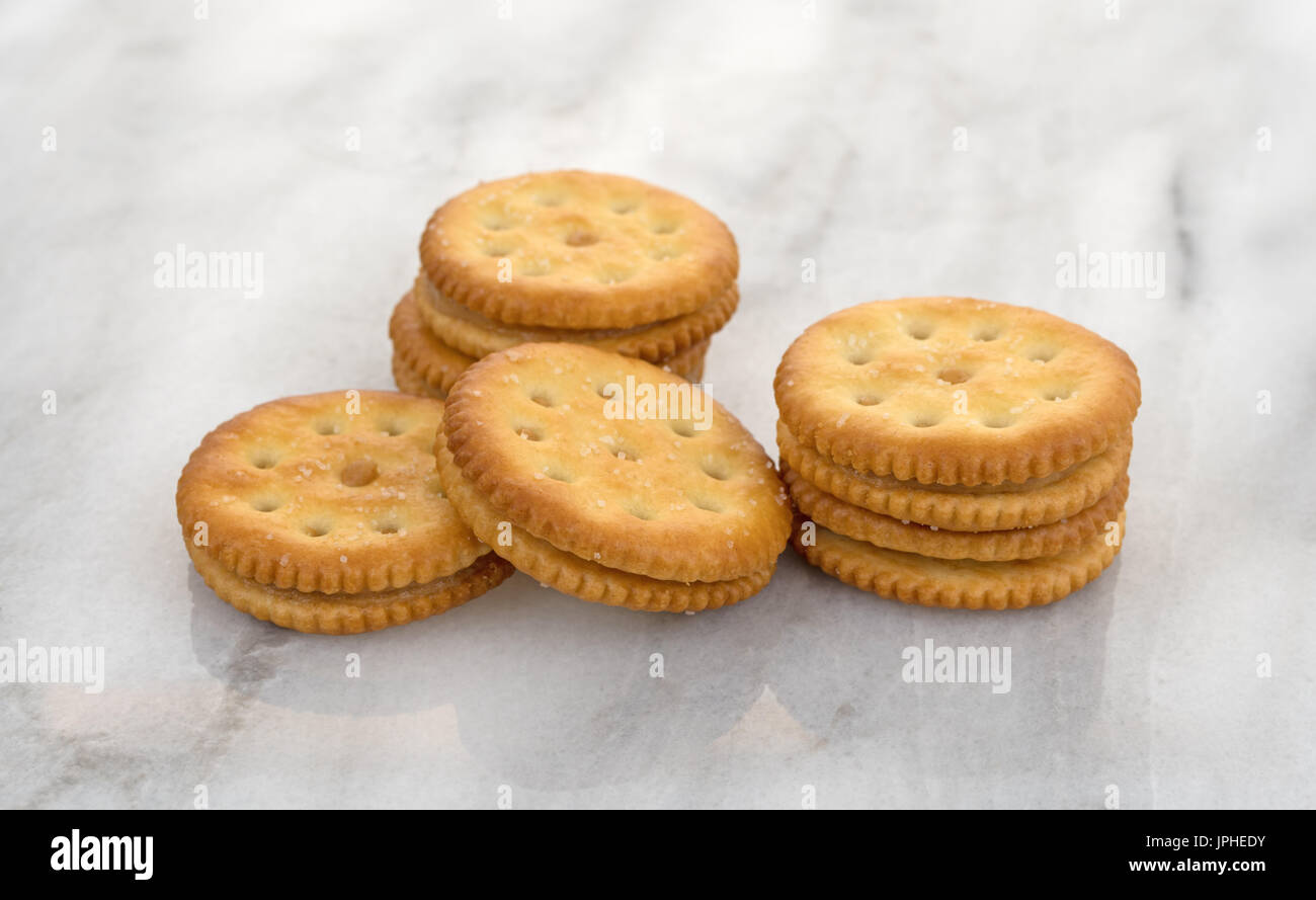 Several roasted peanut butter crackers on a gray marble table top. Stock Photo