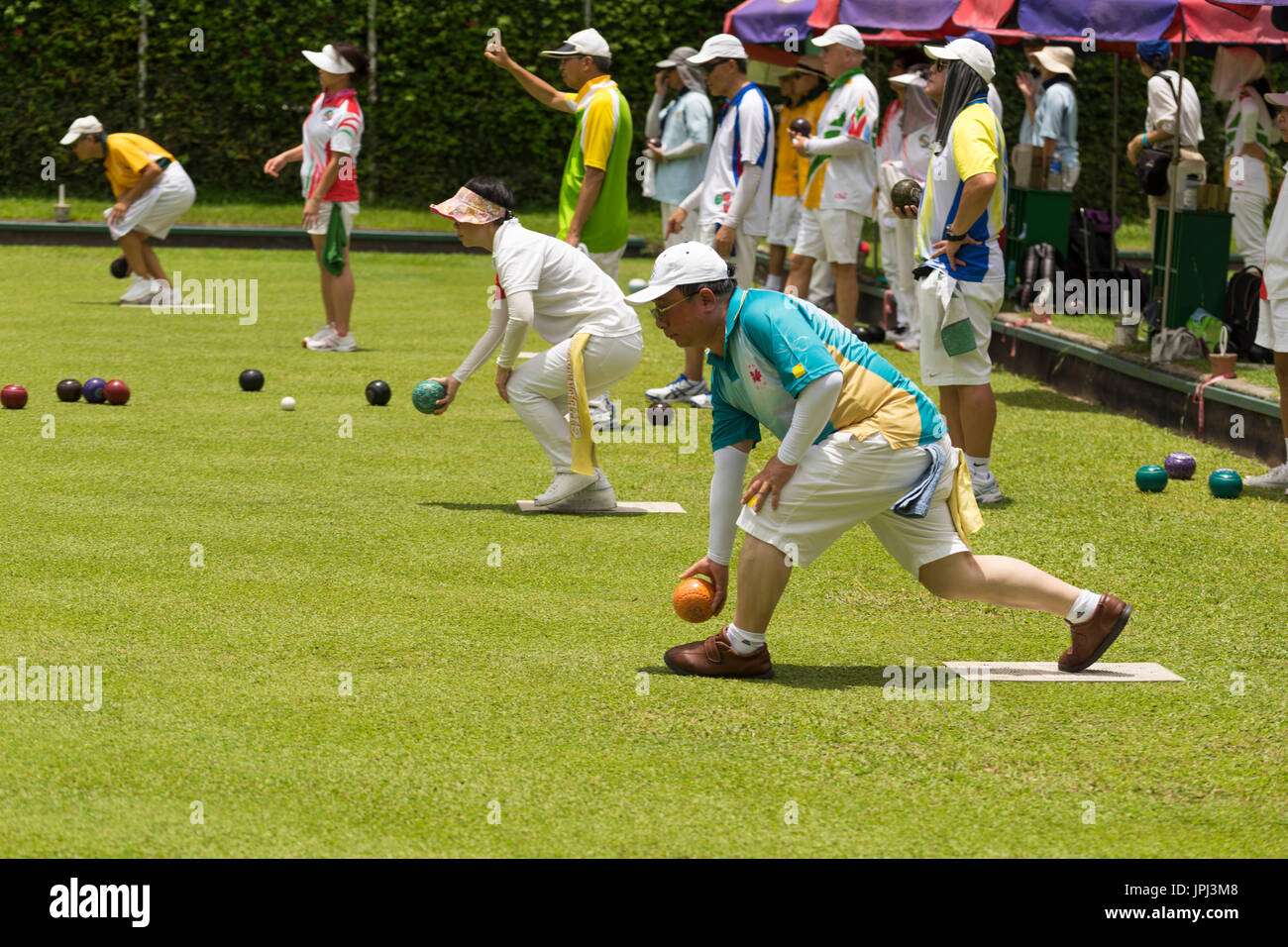 Chinese men and women competing at lawn bowling on a bowling green in Hong Kong Stock Photo Alamy