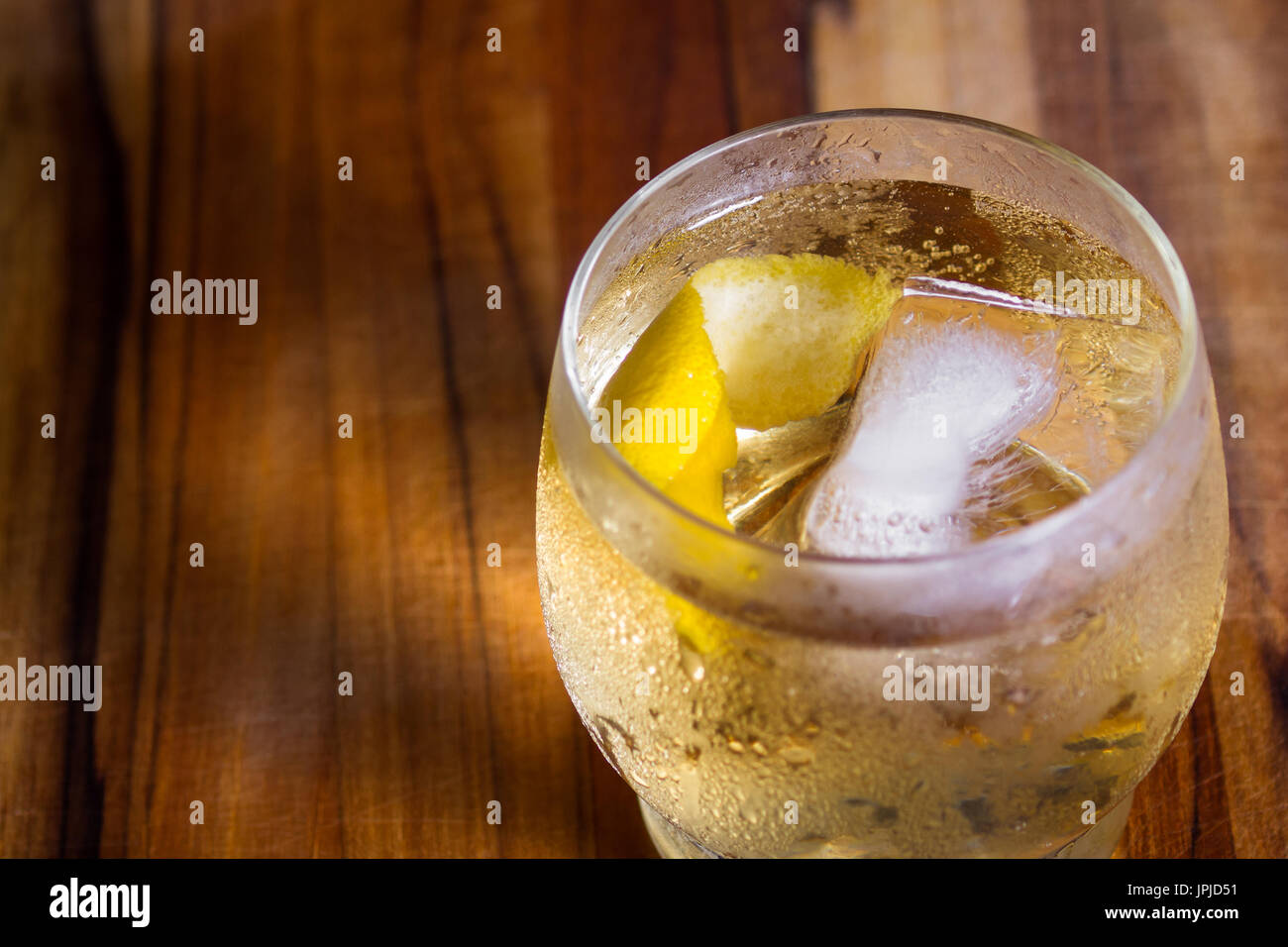 refreshing scotch and soda served on the rocks with a lemon twist on a