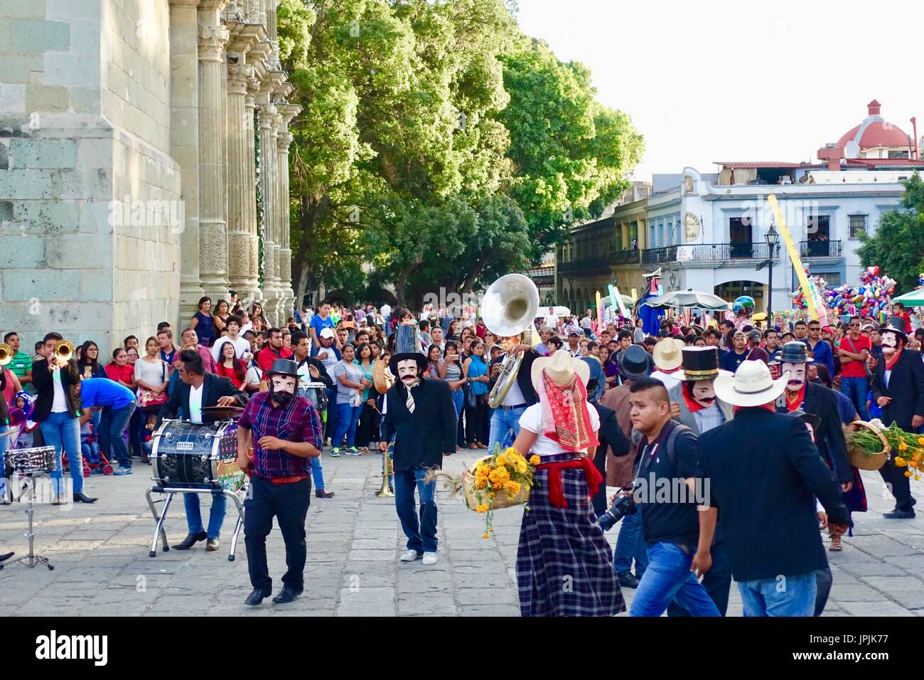 A crowd watches as male dancers in hats and face masks perform traditional dancing in the Zocalo in celebration of the Day of the Dead. Oaxaca, Mexico. Stock Photo