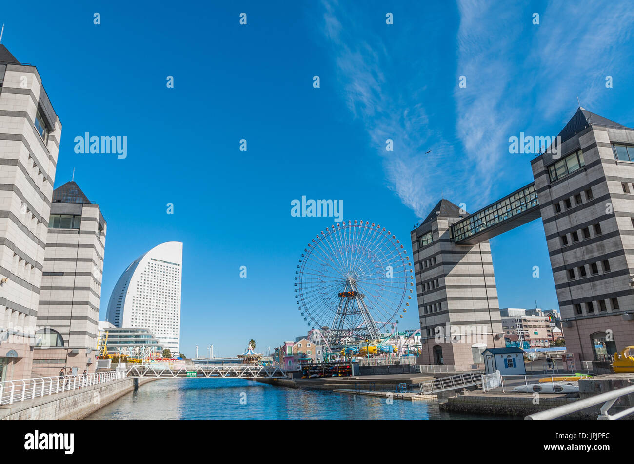 Yokohama, Japan - January 4,2013:The futuristic Yokohama Landmark Tower and the Ferris wheel of the Yokohama Cosmo World theme park. Stock Photo