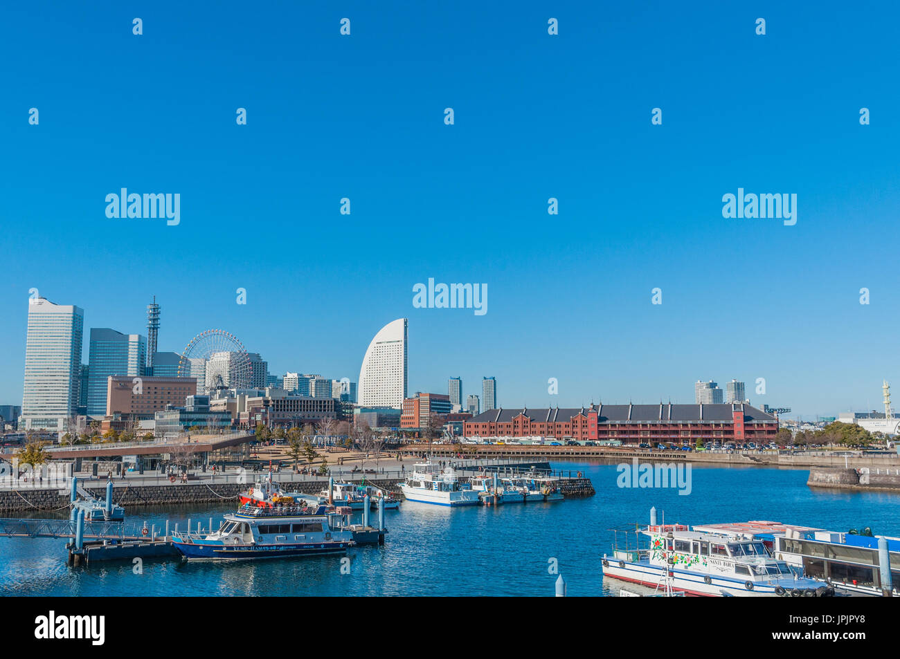 Yokohama, Japan - January 4,2013:The futuristic Yokohama Landmark Tower and the Ferris wheel of the Yokohama Cosmo World theme park. Stock Photo