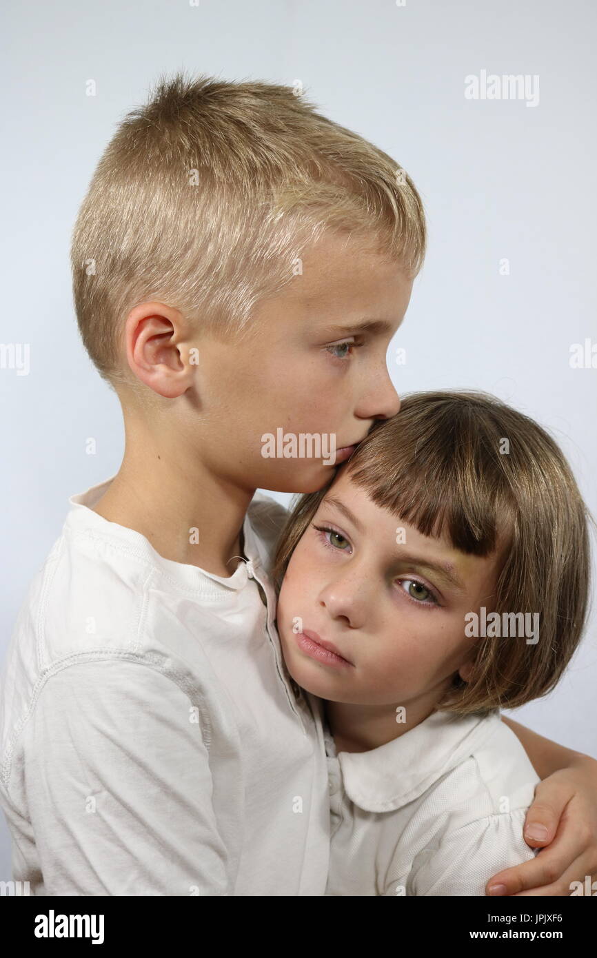 Portrait of brother comforting little sister with black eye Stock Photo