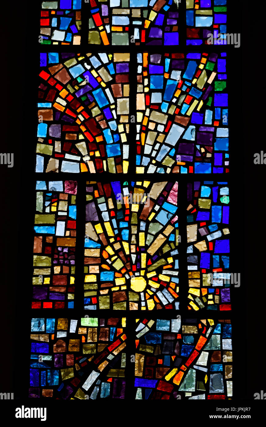 Abstract multicolor sun pattern of a stained glass window mosaic in a Toronto Roman Catholic church Stock Photo