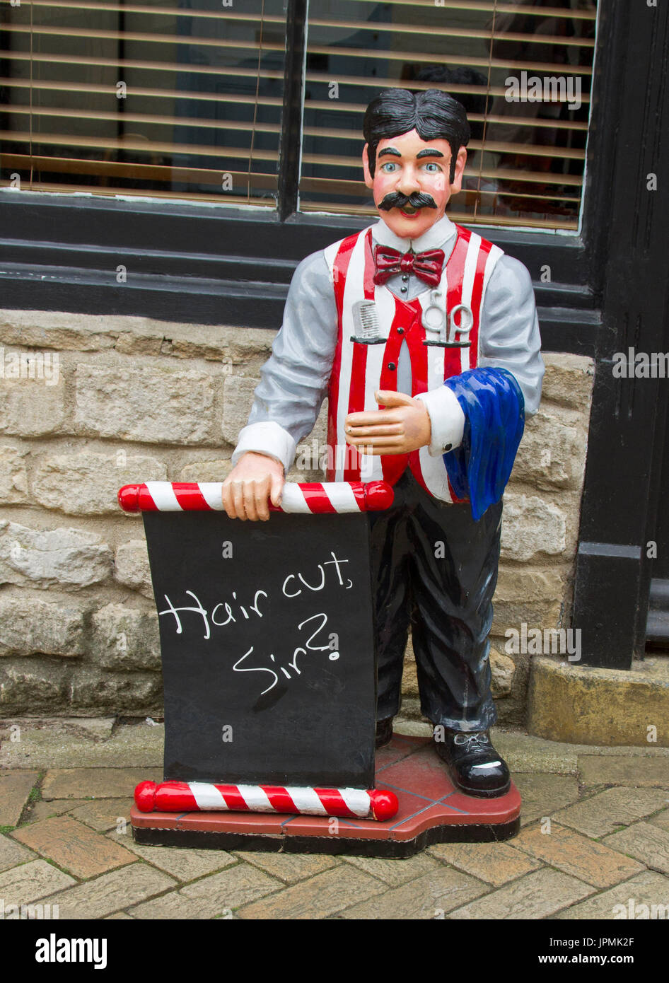 Unique, colourful, and humorous sign on footpath outside barber's shop with  statue of old fashioned barber asking 'A hair cut Sir?' Stock Photo - Alamy