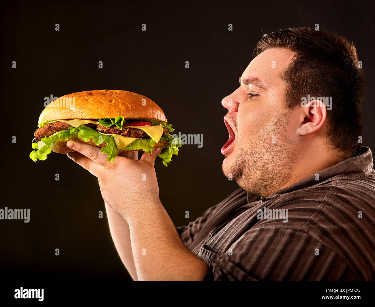 Fat man eating fast food hamberger. Breakfast for overweight person Stock  Photo - Alamy