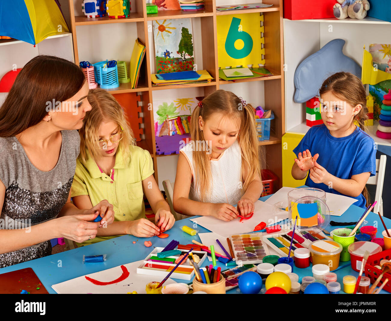 Plasticine Modeling Clay In Children Class. Teacher Teaches Kids Together  Play Dough And Mold From Plasticine In Kindergarten Or Preschool. Group Of  Four People. Zoo From The Clay. Stock Photo, Picture and