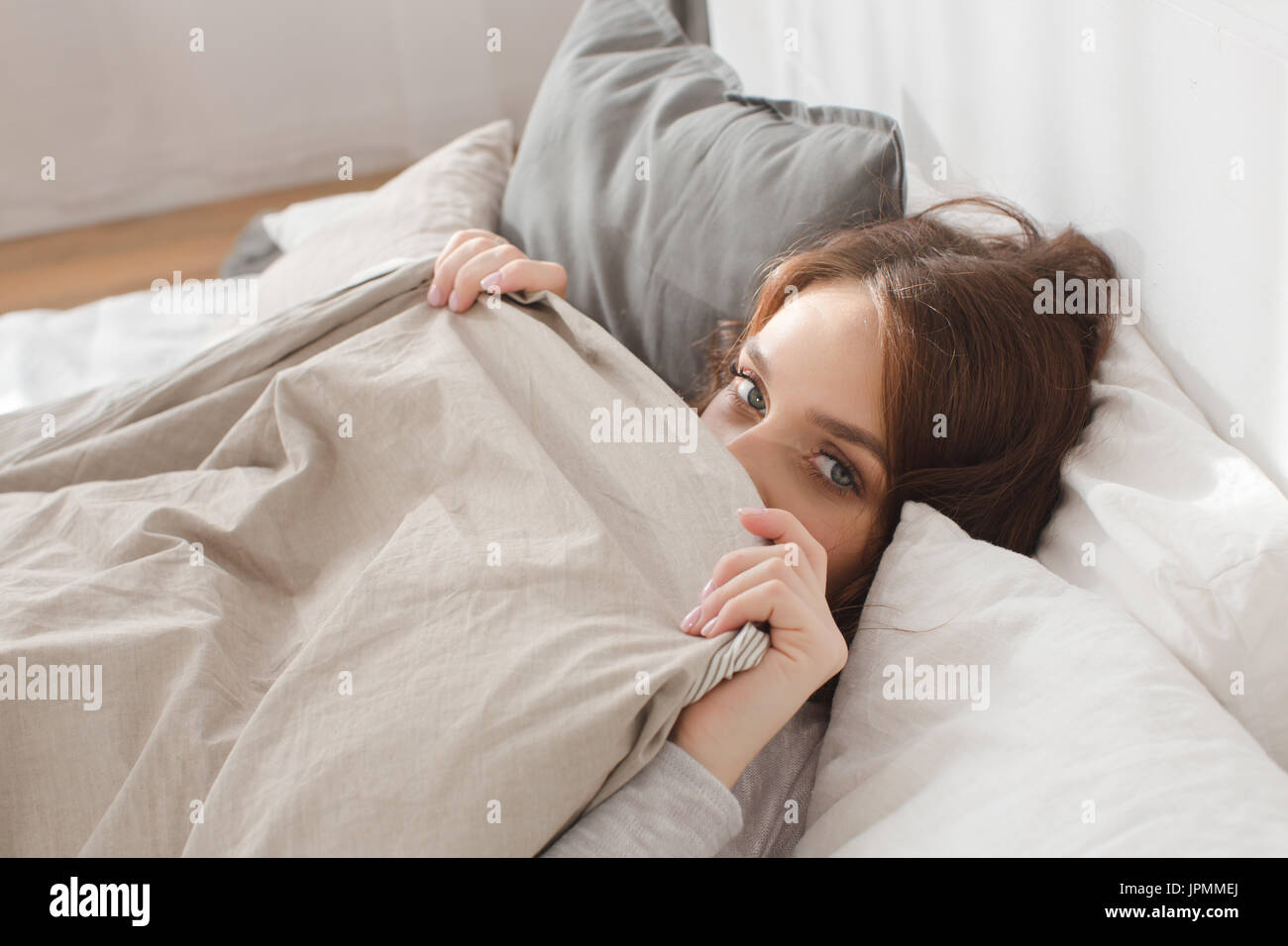 Female lying covered with blanket Stock Photo Alamy