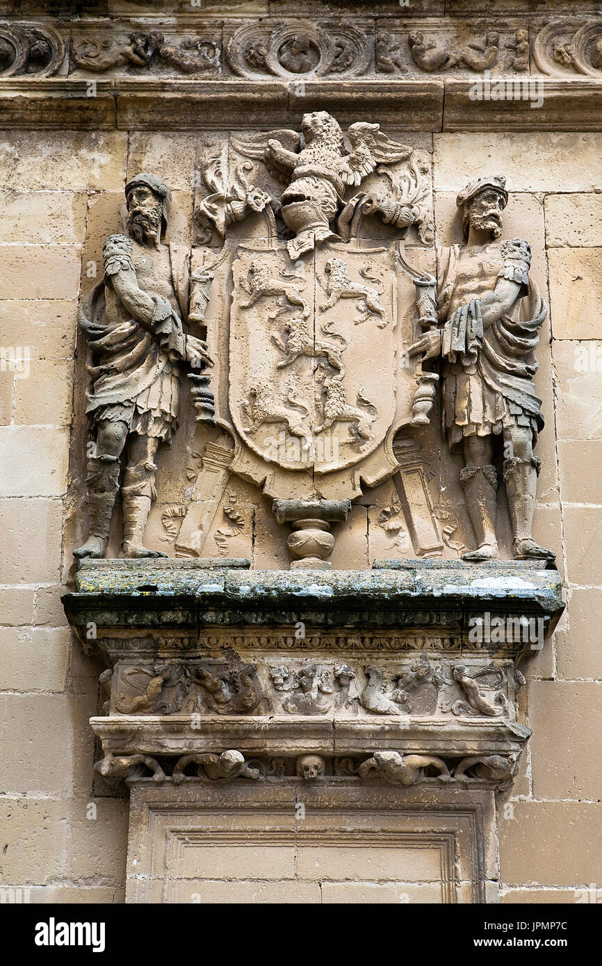 Shield of stone framed by two men, relief of the Front of the chapel of El Salvador of Ubeda, Jaen province, Andalusia, Spain Stock Photo
