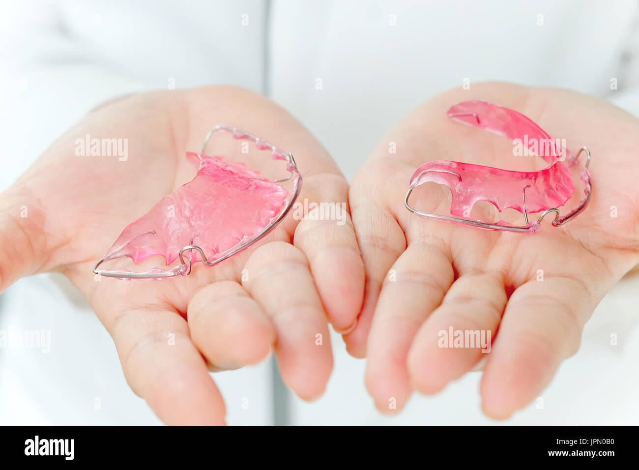 Dentist holding Retainer, Orthodontics Dental concept background Stock
