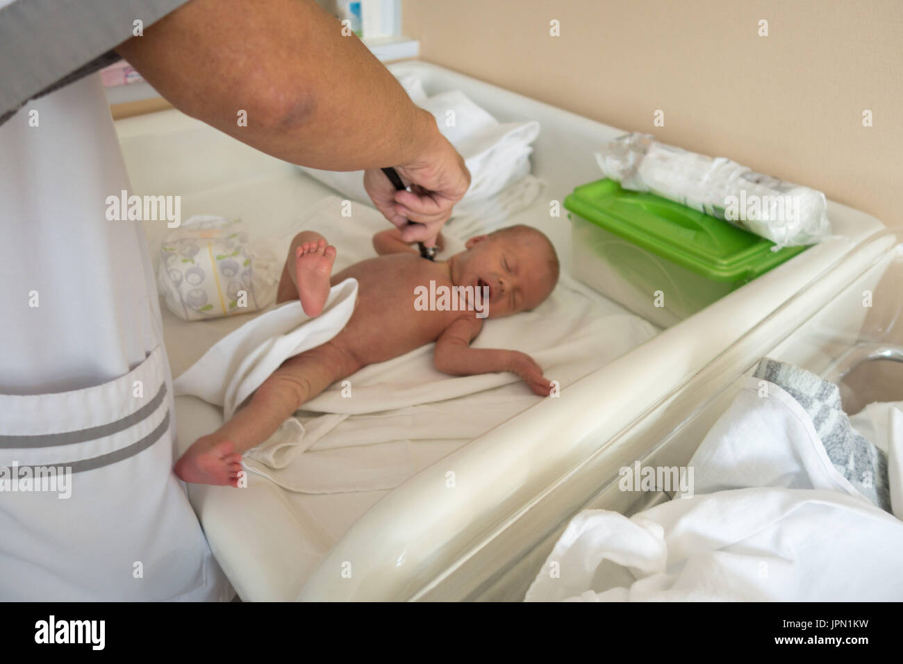 Doctor exploring baby in cradle Stock Photo