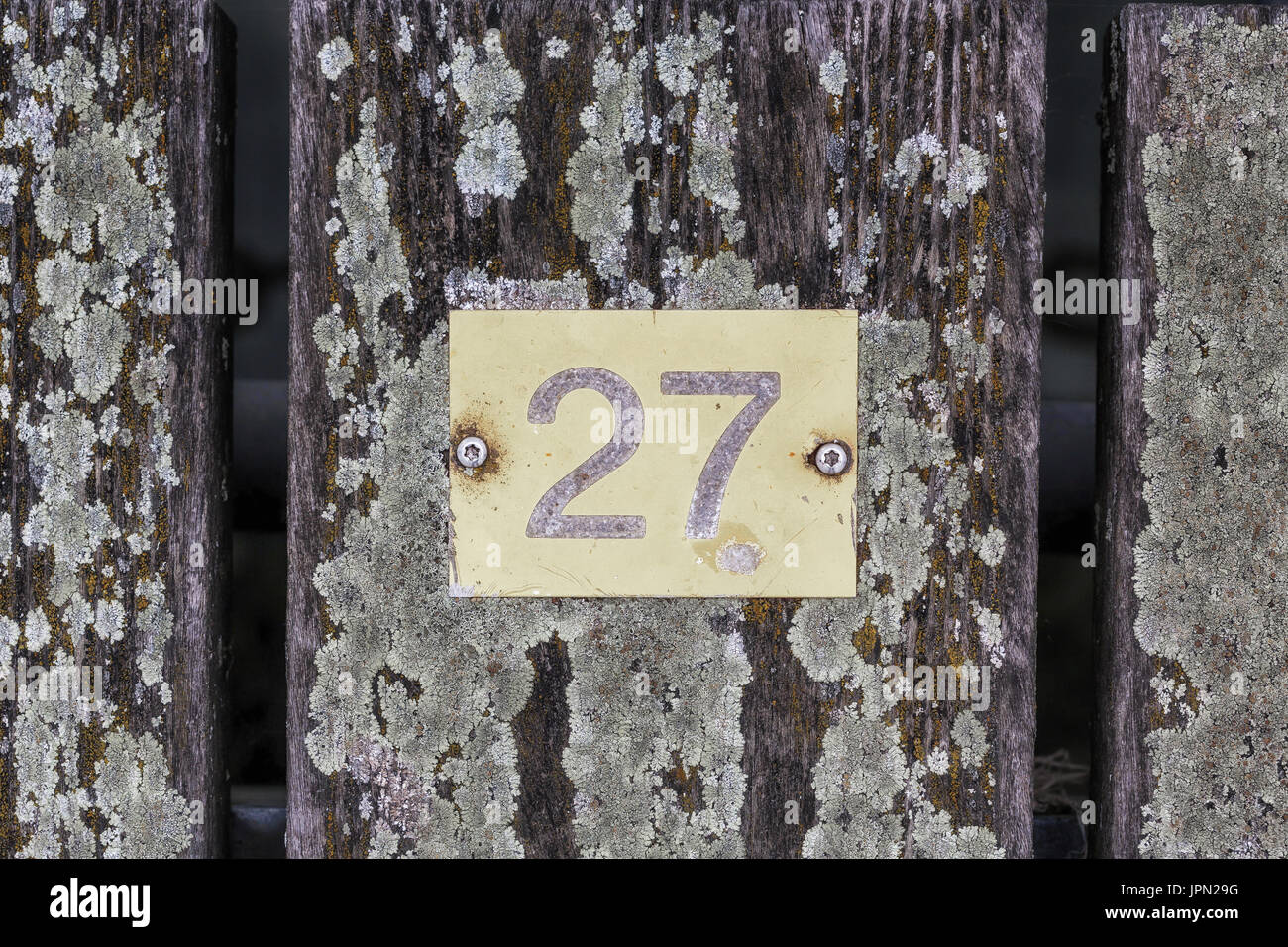An iron plate marked twenty-seven on wooden planks. Stock Photo
