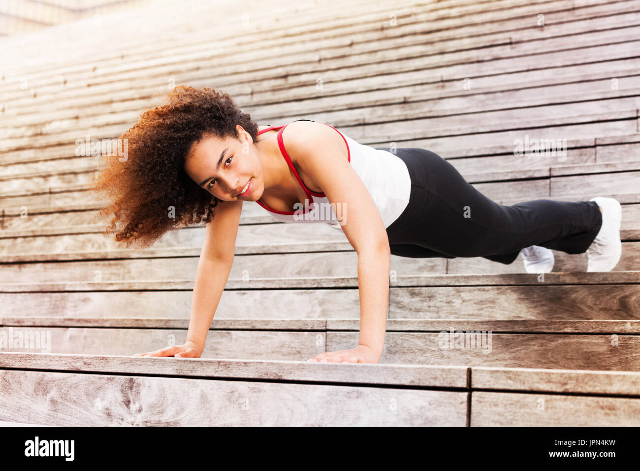 African sportswoman doing push-ups outdoors Stock Photo - Alamy