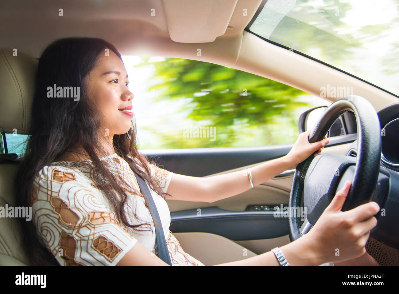 Asian girl driving a car on the highway Stock Photo