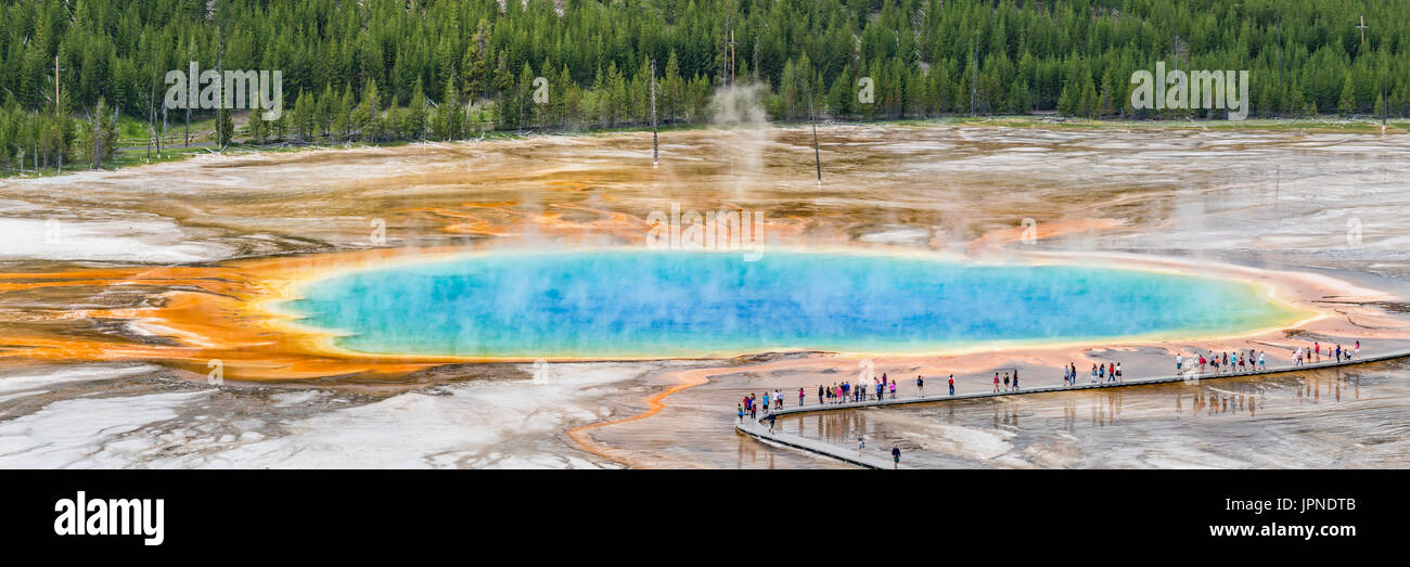 Tourists line the boardwalk at the Grand Prismatic Spring in Midway Geyser Basin in Yellowstone National Park, Wyoming. Stock Photo