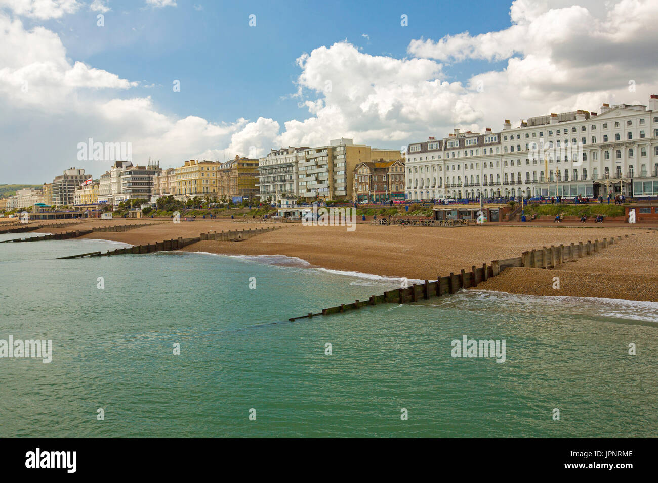 Deserted beach, turquoise water of ocean, and row of waterfront hotels and guesthouses at English holiday destination of Eastbourne Stock Photo
