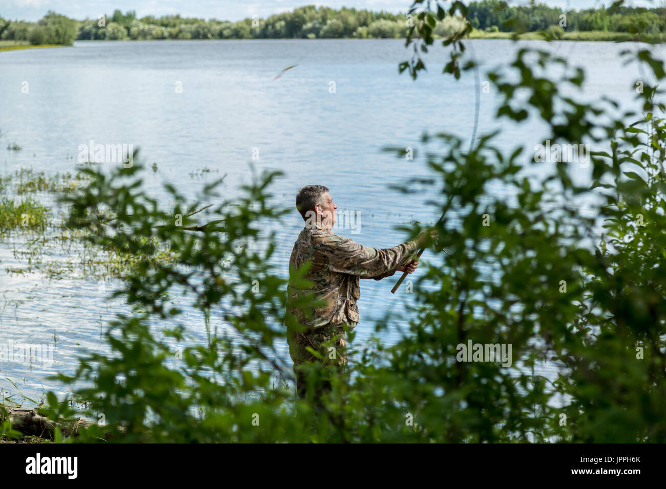 The fisherman catches a pike for spinning off the bank of the channel