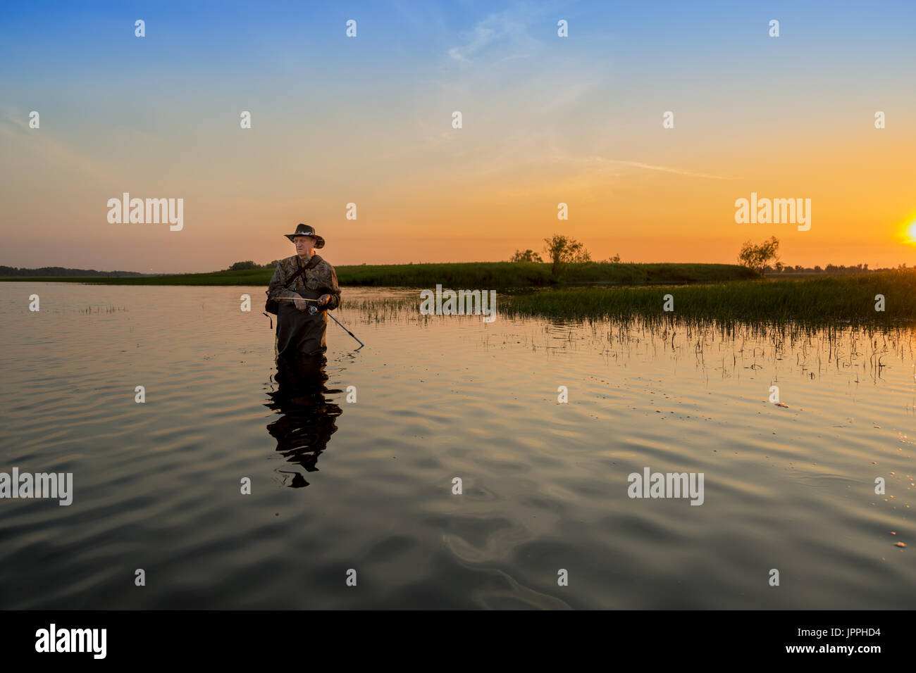 The fisherman catches a pike for spinning off the bank of the channel