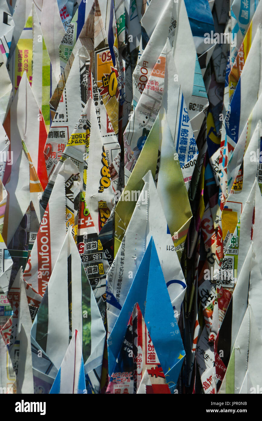 Close up of many folded origami cranes made from magazine or newspaper advertisements. Stock Photo