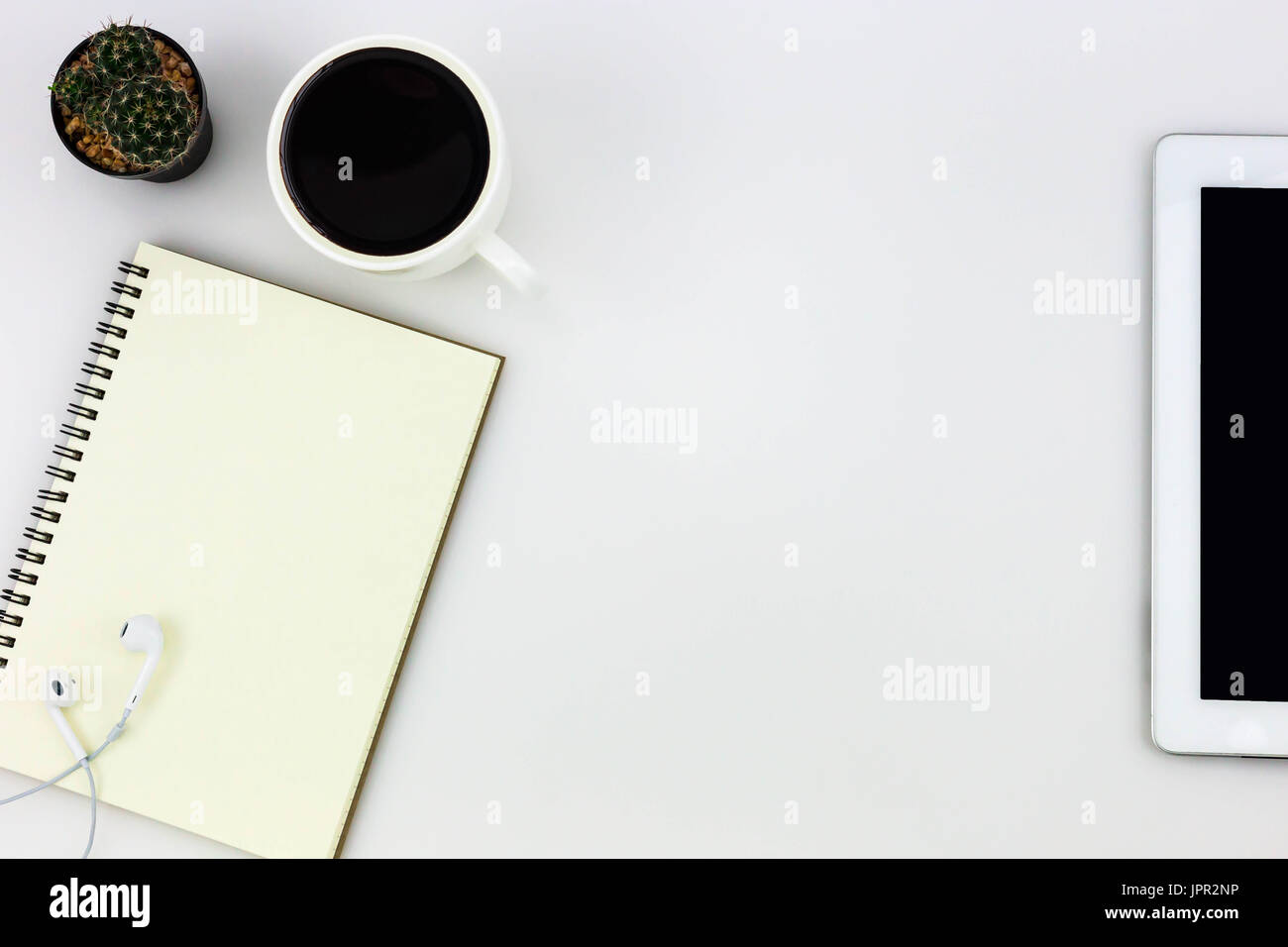 Modern white office desk top table with tablet, a cup of coffee