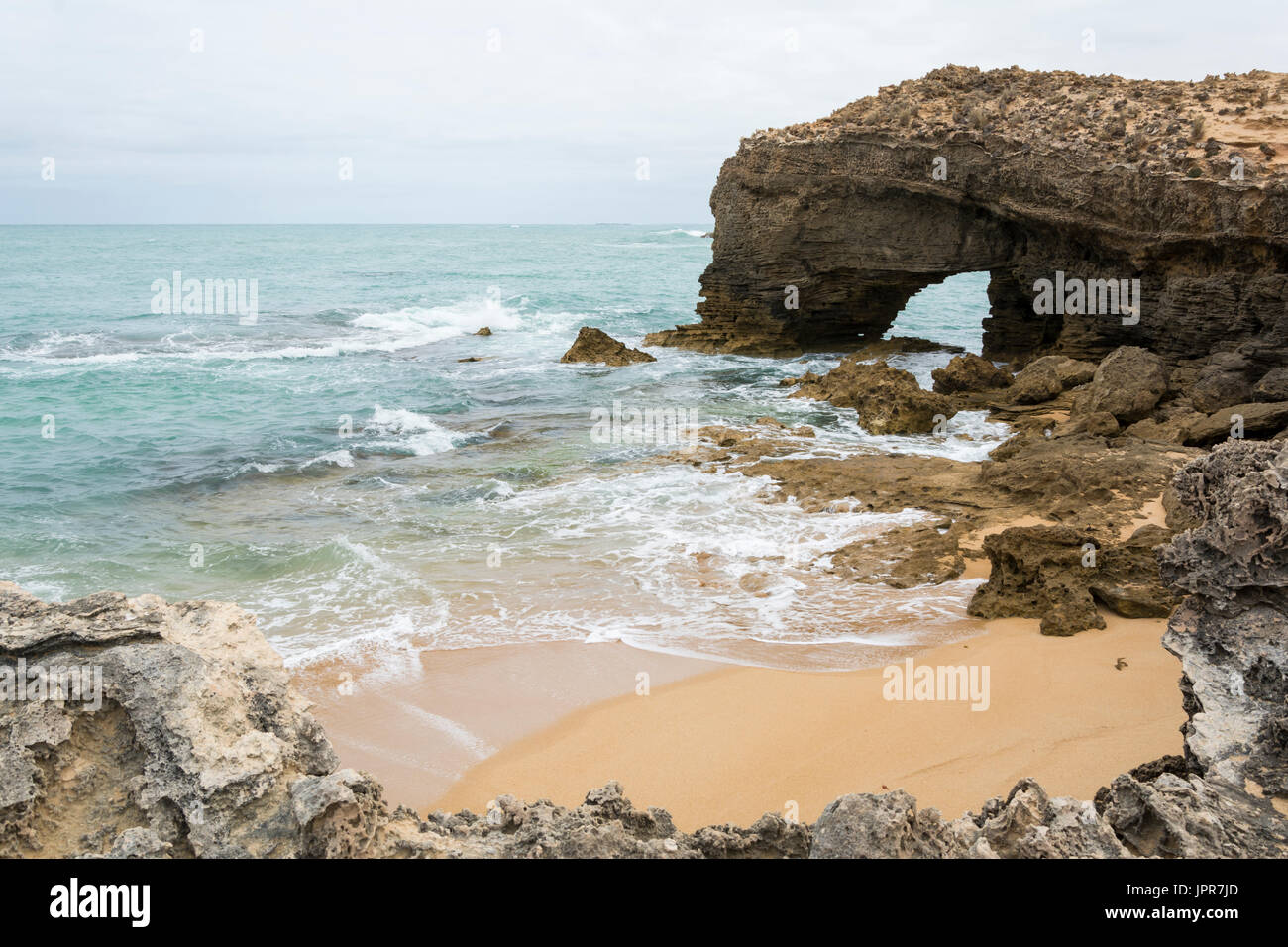 Arched rock formation on a coastal beach, near the light house at Robe, situated within the South East coastal region of South Australia, Stock Photo