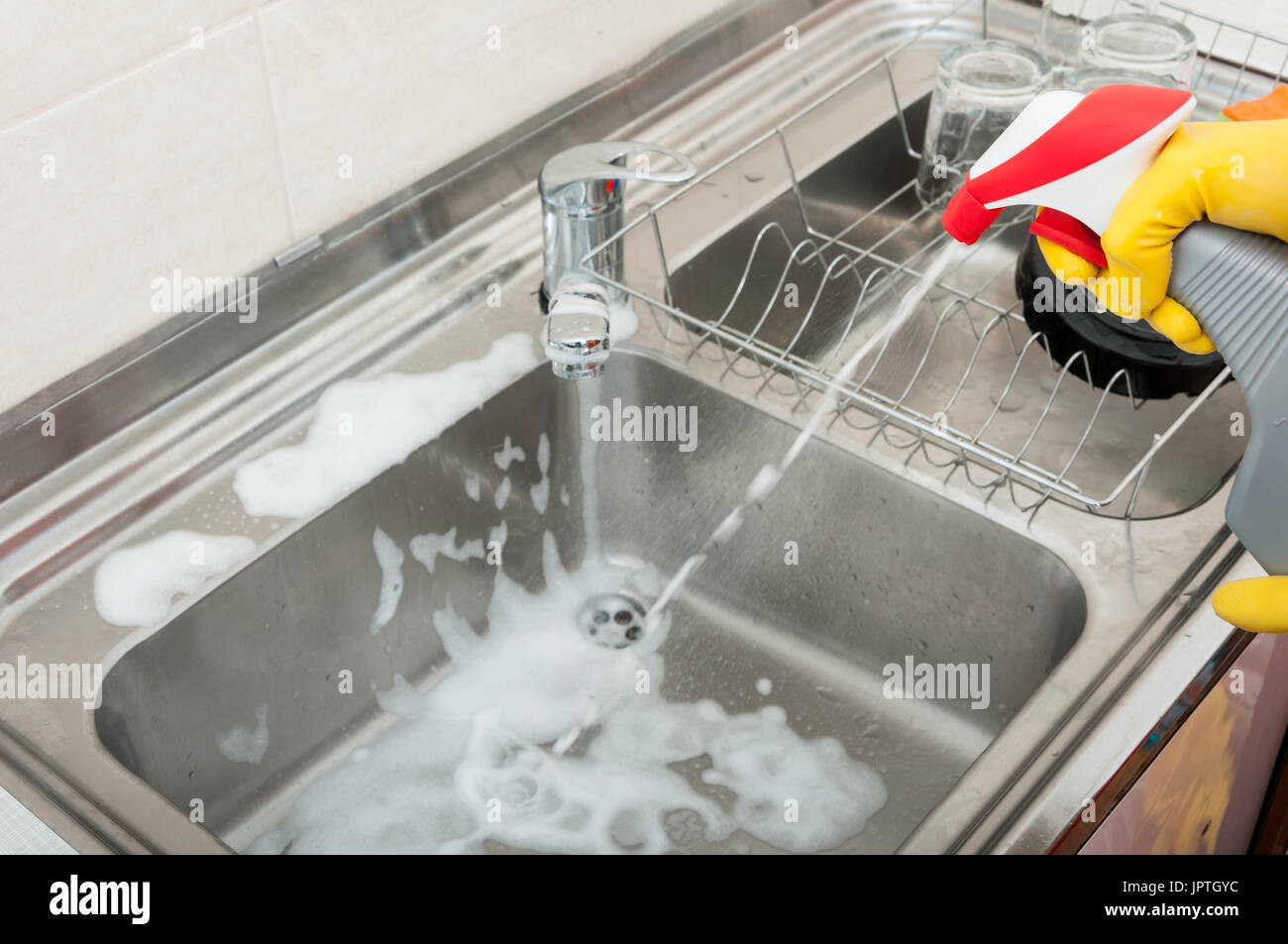 Housekeeping person washing and disinfecting the sink with cleaning