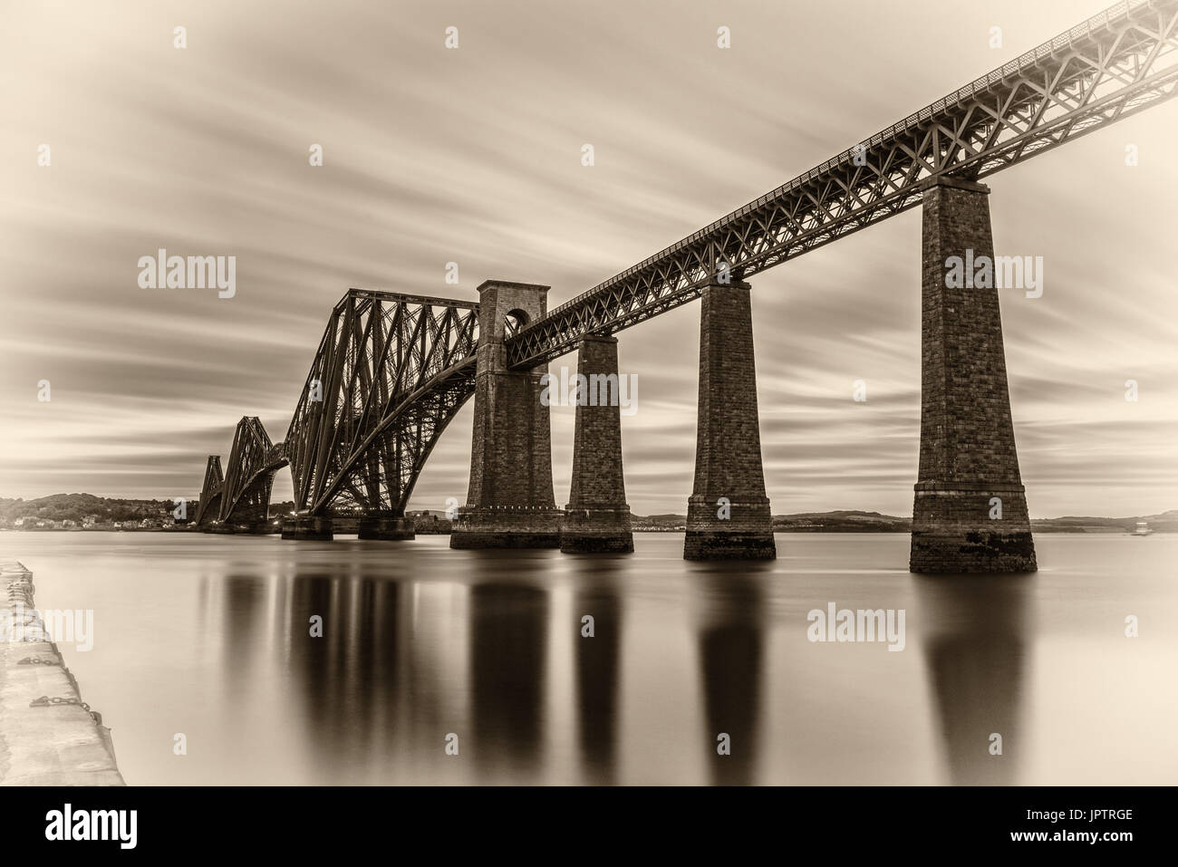 Forth Railway Bridge over the Firth of Forth at sunset in Edinburgh, Scotland, United Kingdom. Vintage black and white processed. Stock Photo