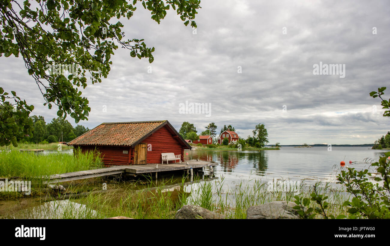 The old timbered boat-house with the liars bench on the bridge in the northern part of Stockholm archipelago, Bjorko-Arholma, Marum Stock Photo