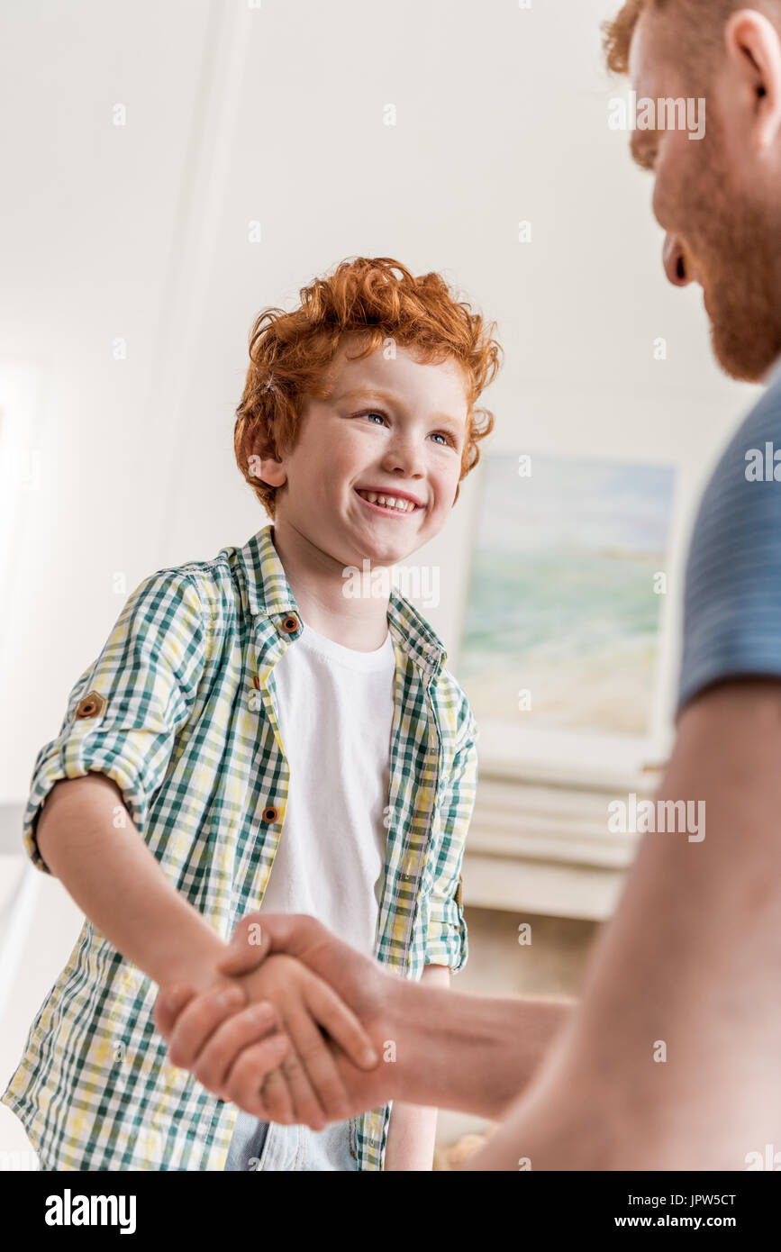 side view of father and smiling son shaking hands Stock Photo Alamy