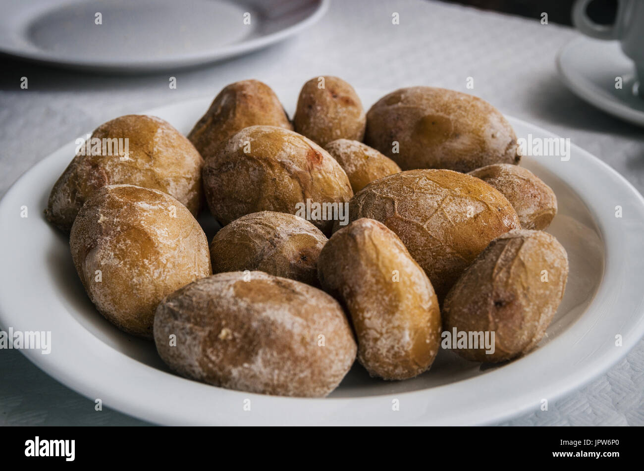Papas arrugadas - small canarian wrinkly potatoes with salt on a plate close up. Brewed in sea water Stock Photo