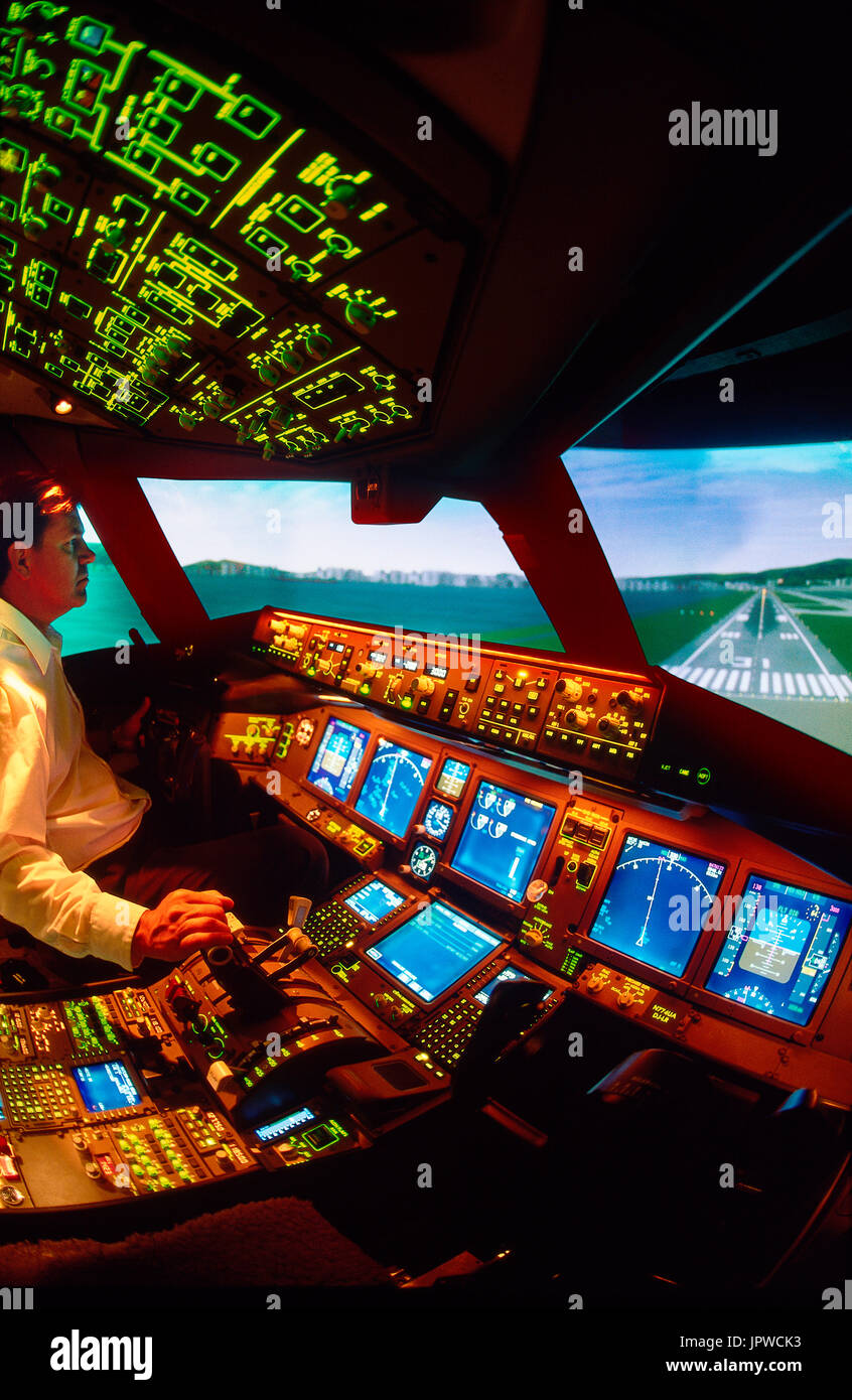 pilot in Captain's seat in a cockpit simulator on final-approach to landing Stock Photo