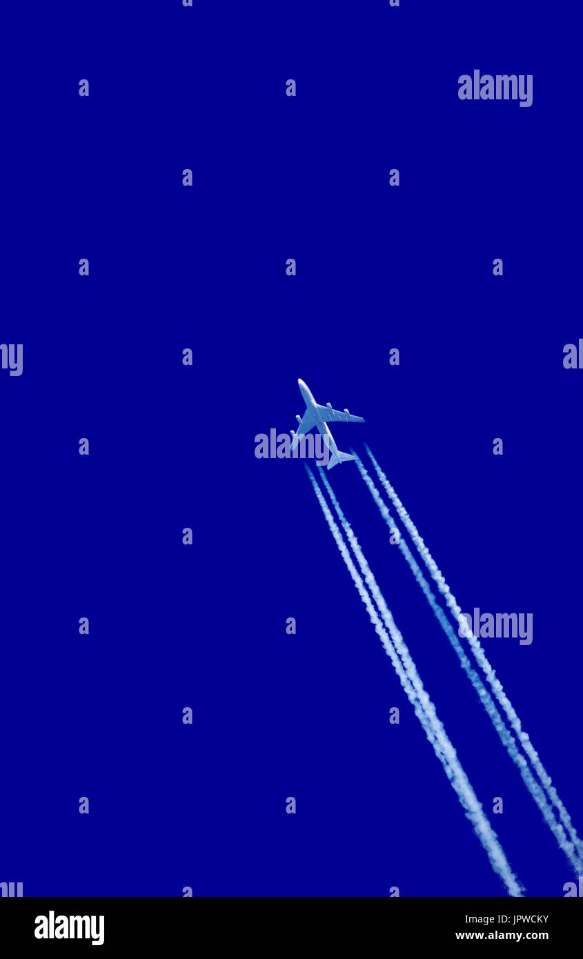 Boeing 747-200 making contrail vapour trail against blue-sky Stock Photo