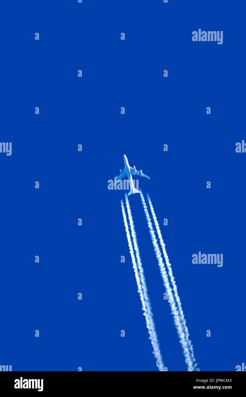 Boeing 747-400 making contrail vapour trail against blue-sky Stock Photo