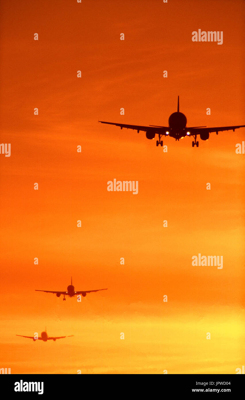 Airbus A320 and other airliners on a busy final-approach at sunset Stock Photo