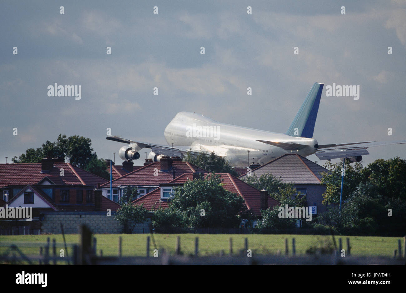 Boeing 747-100 on final-approach flying over houses Stock Photo - Alamy