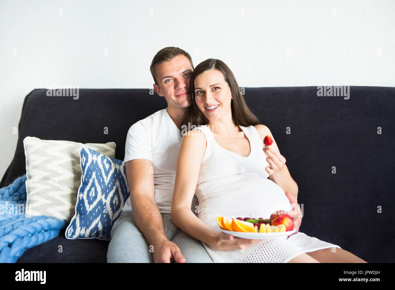 Young smiling pregnant pretty woman and man with fruit Stock Photo - Alamy