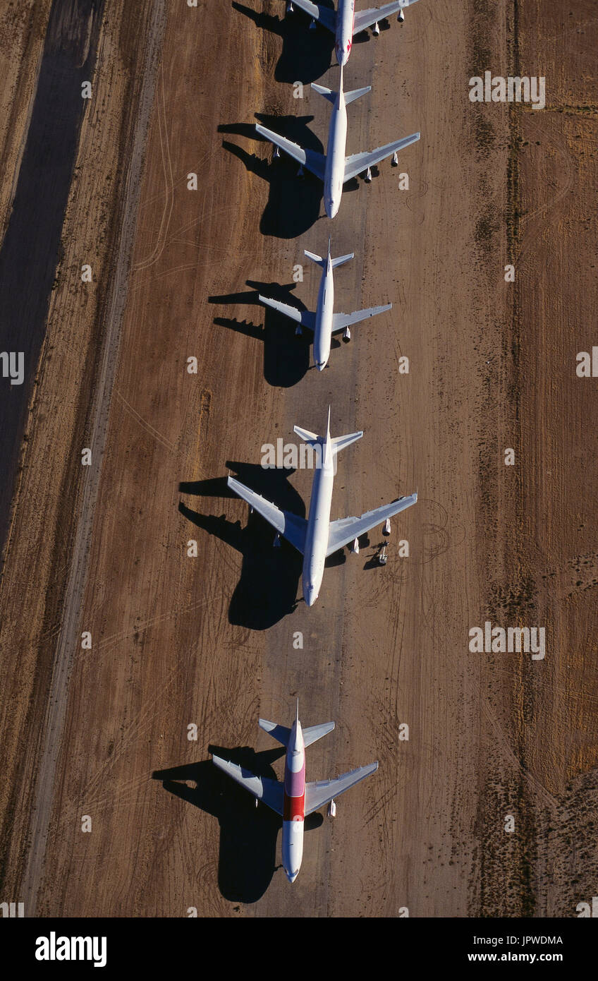 row of Lockheed L-1011 Tristars, Boeing 747s and Airbus A300s parked after retirement in desert-storage Stock Photo