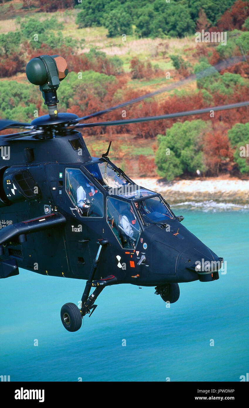 Eurocopter Tigre prototype flying with trees and sea behind Stock Photo
