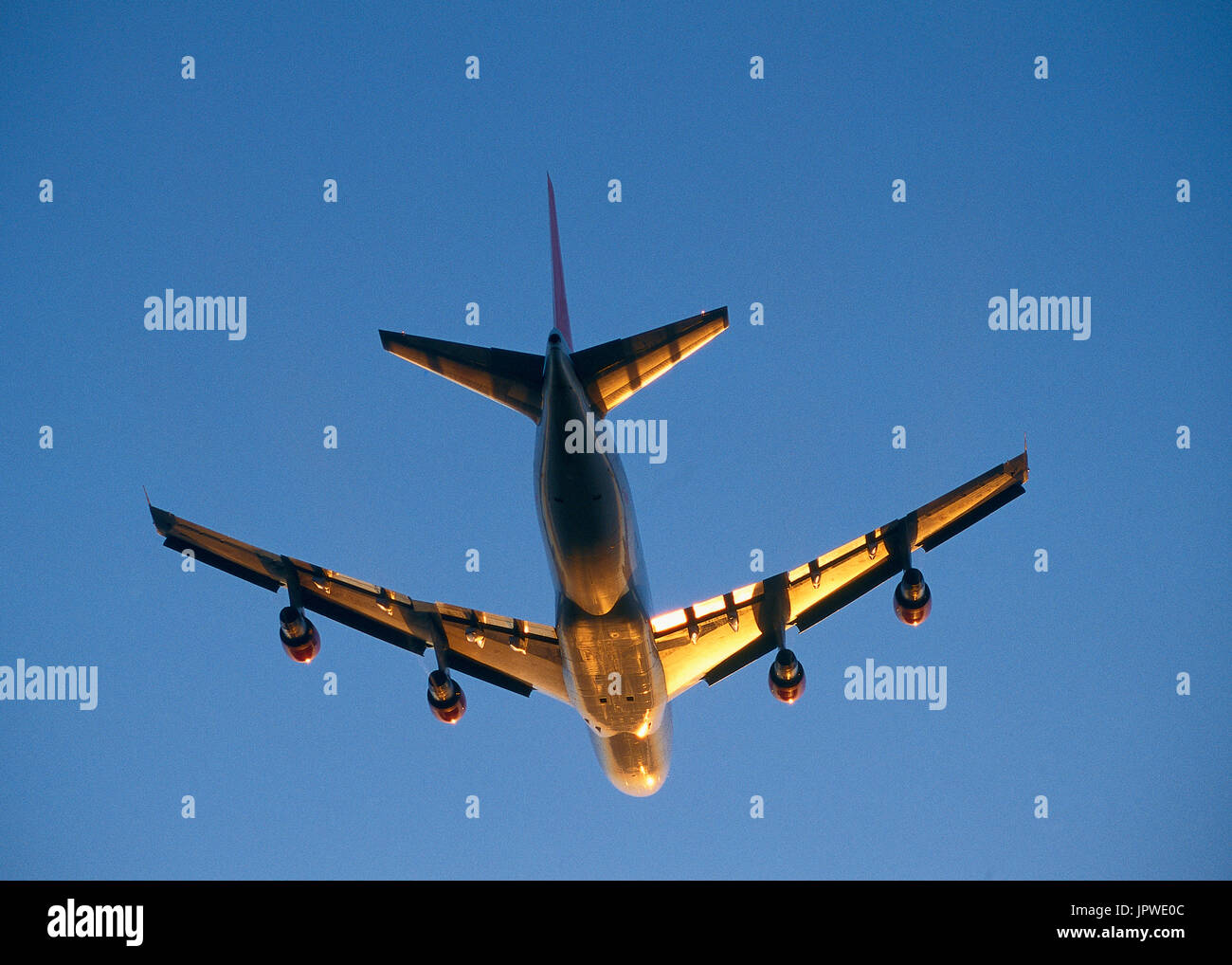 Virgin Atlantic Airways Boeing 747-200 with a golden light glinting off the underside climbing enroute Stock Photo