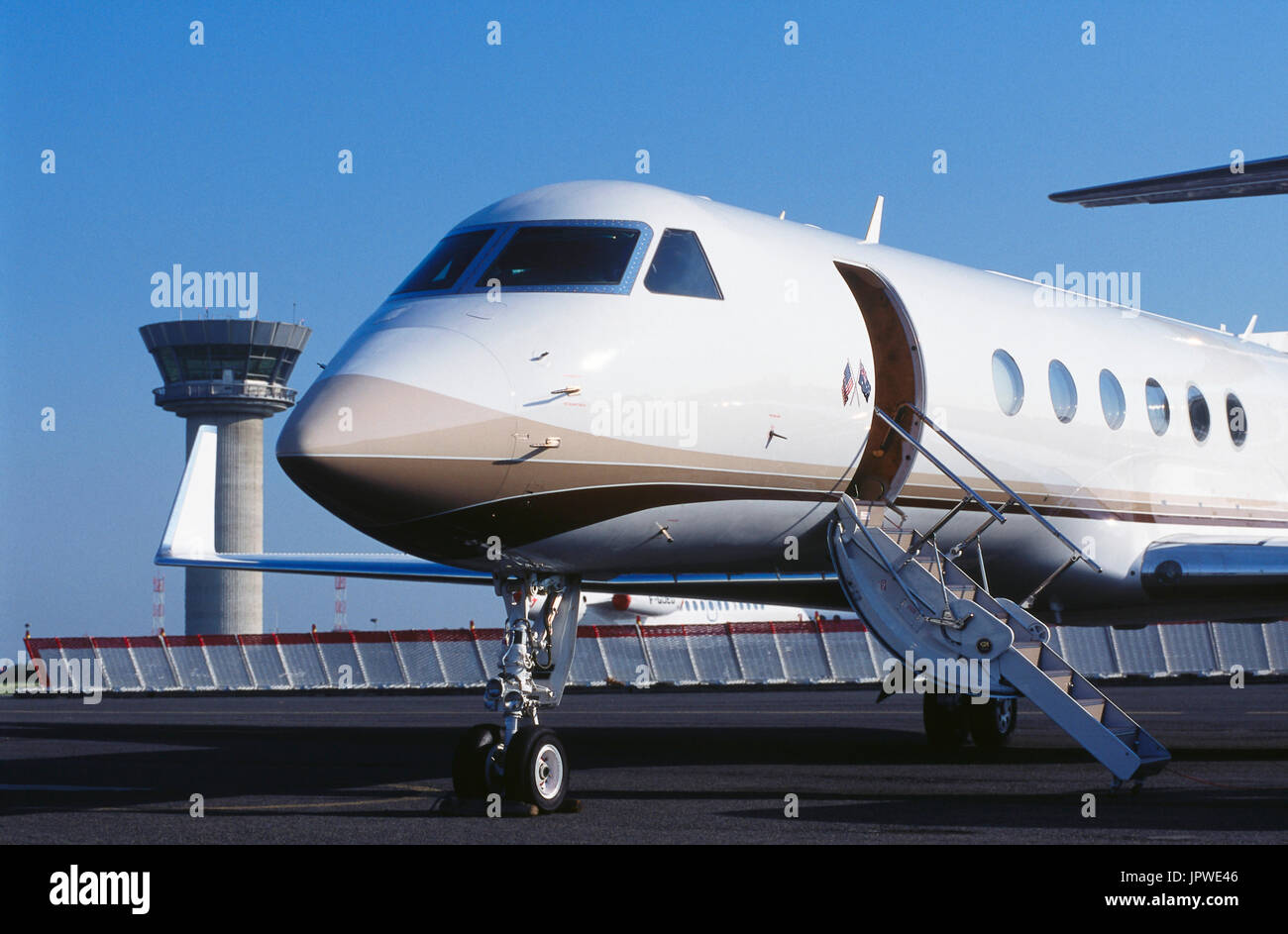 Gulfstream 500 parked with blast fence and air-traffic control-tower behind nose-wheel undercarriage, airstairs and winglet of golfer Greg Norman's pr Stock Photo