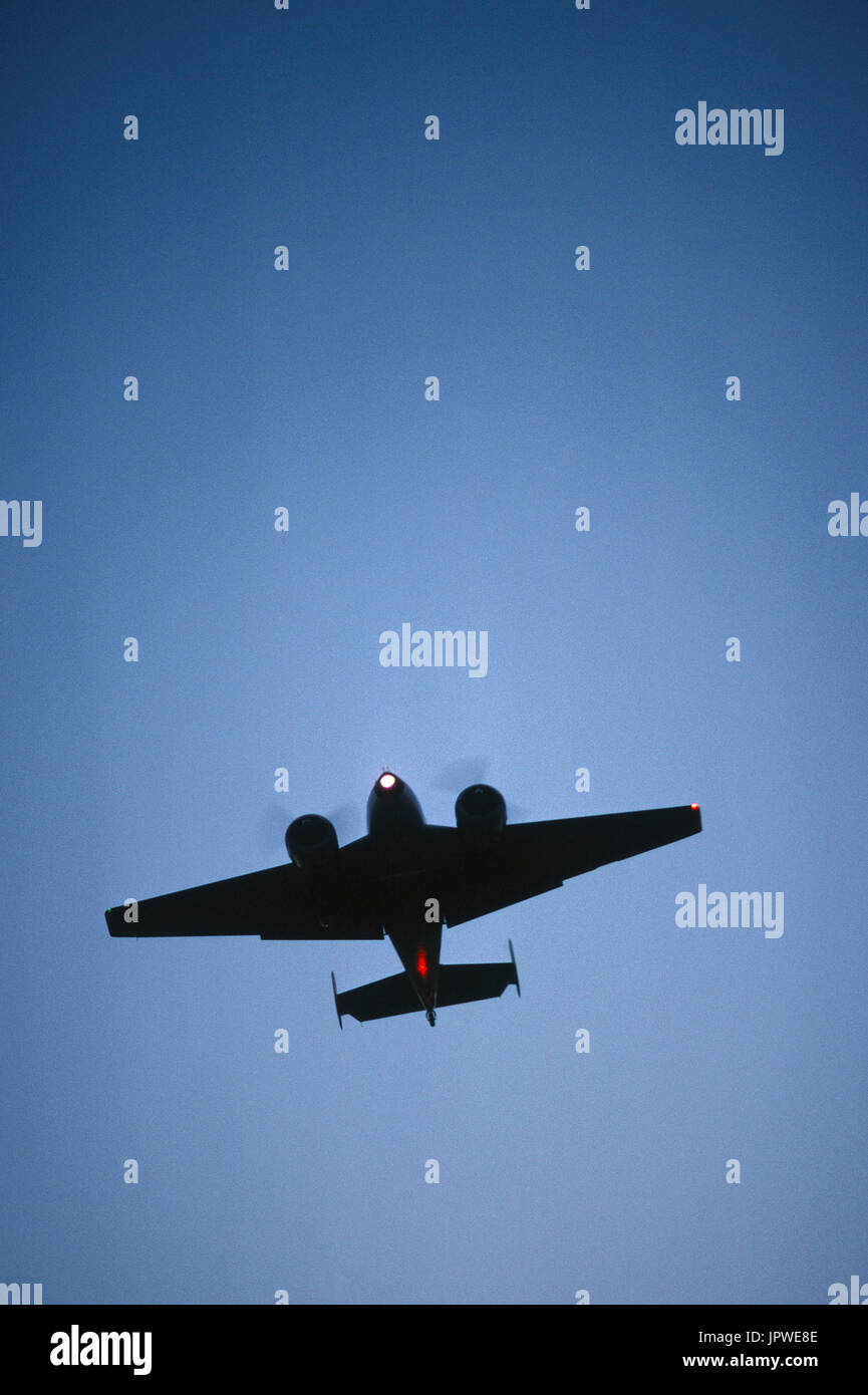 Beech 18 on final-approach with lights on, undercarriage and flaps down at dusk Stock Photo