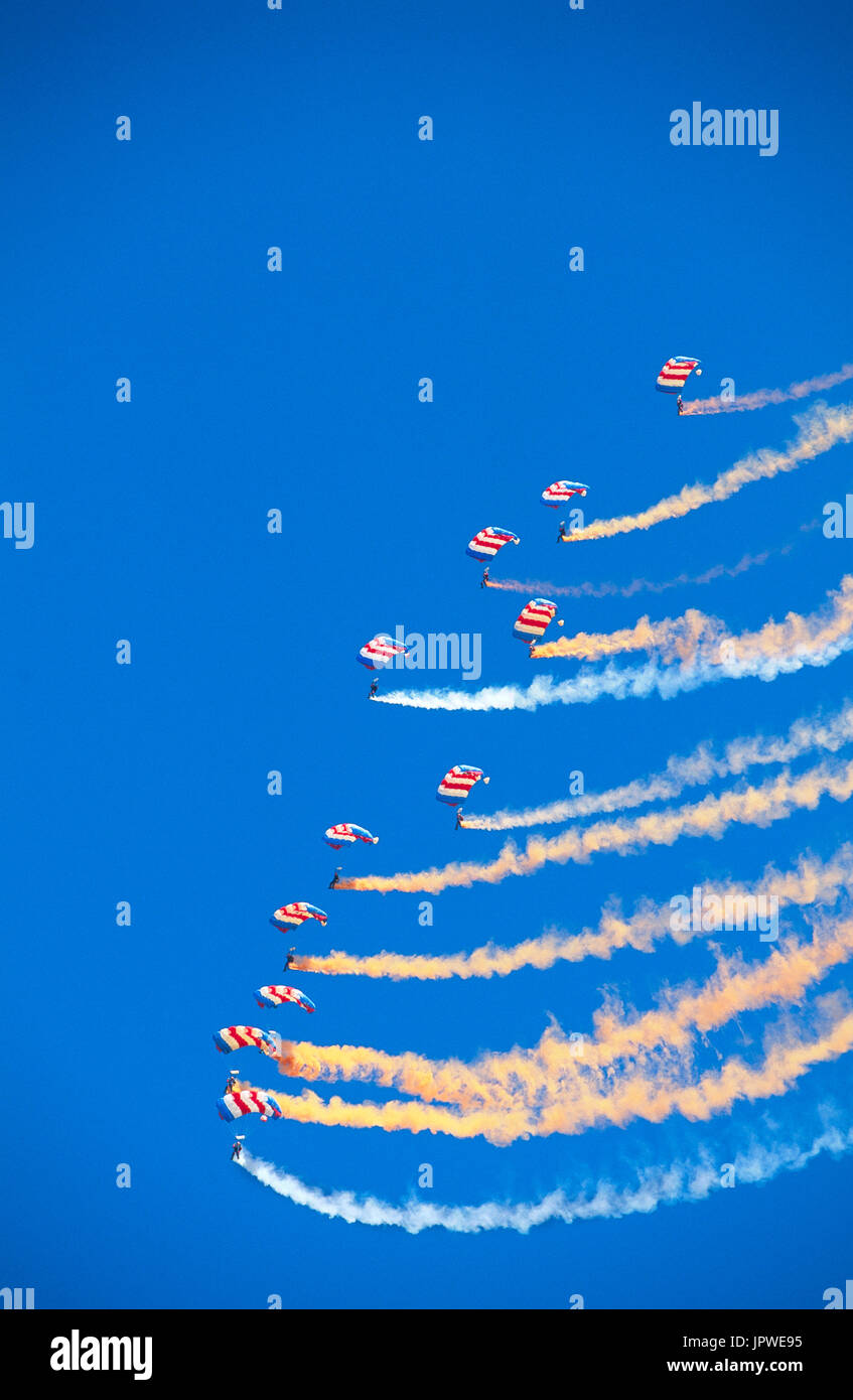 generic parachute formation team trailing orange and white smoke Stock Photo