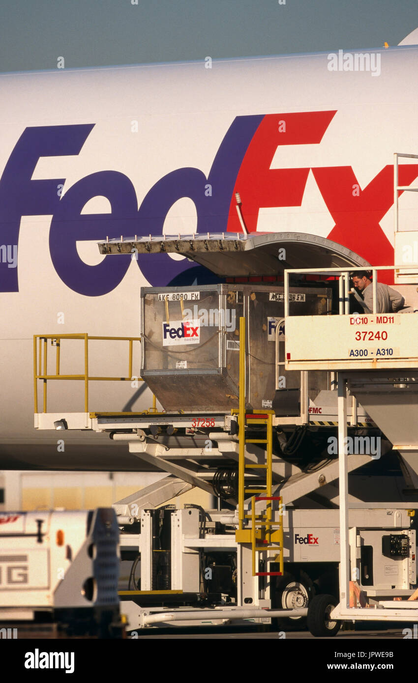 LD3 containers being loaded into lower side cargo door of a FedEx Airbus A300-600 freighter Stock Photo