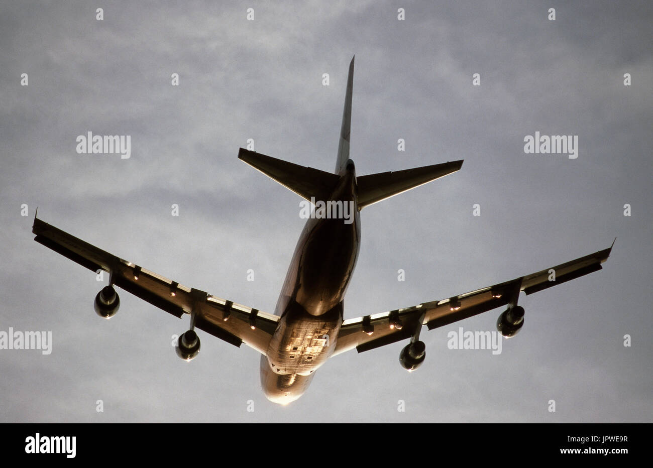 generic Boeing 747-100 climbing enroute at dusk with sun glinting off the fuselage and wings Stock Photo