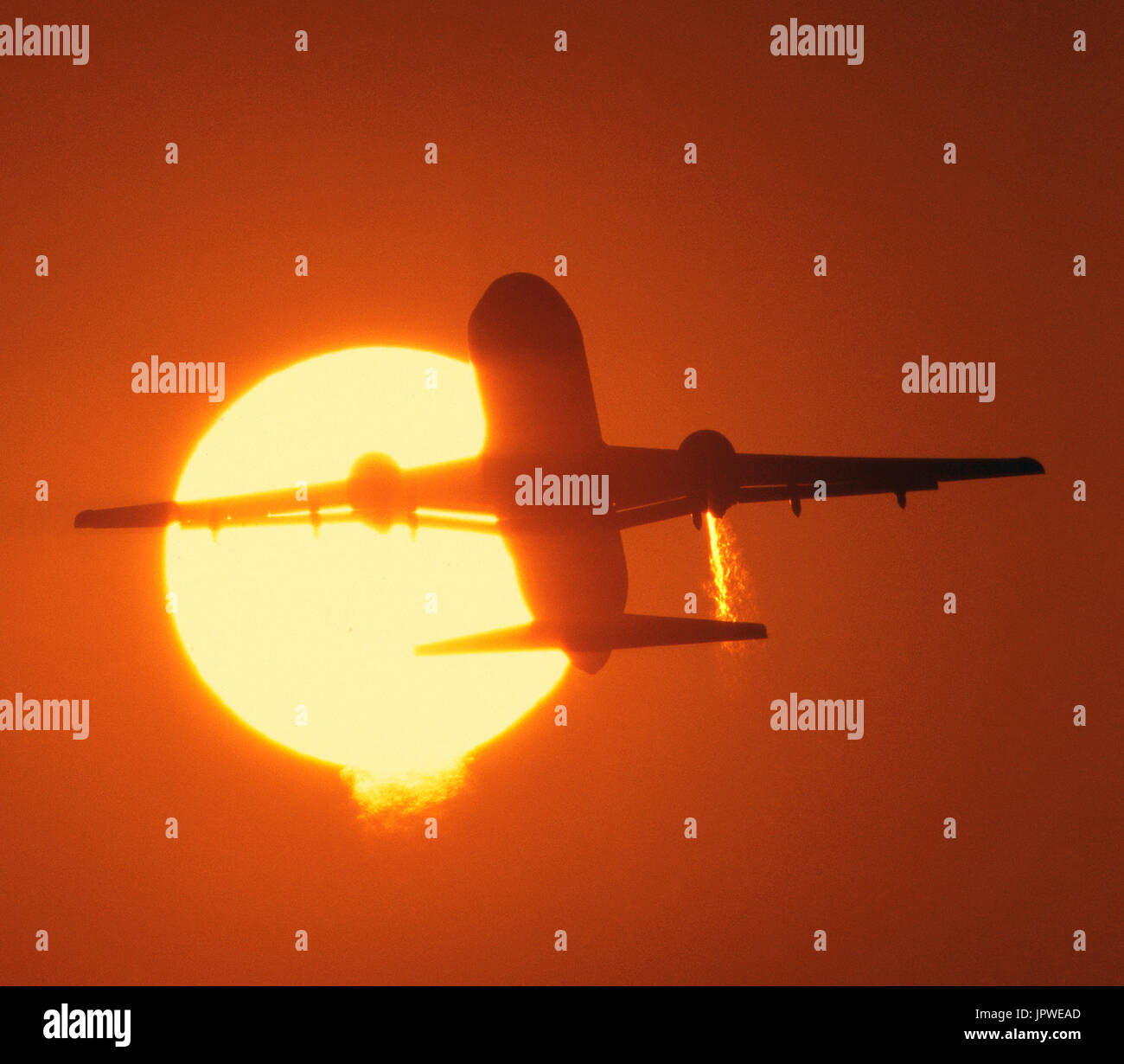 Airbus A320 climbing enroute through the sunset with jet-exhaust visible Stock Photo