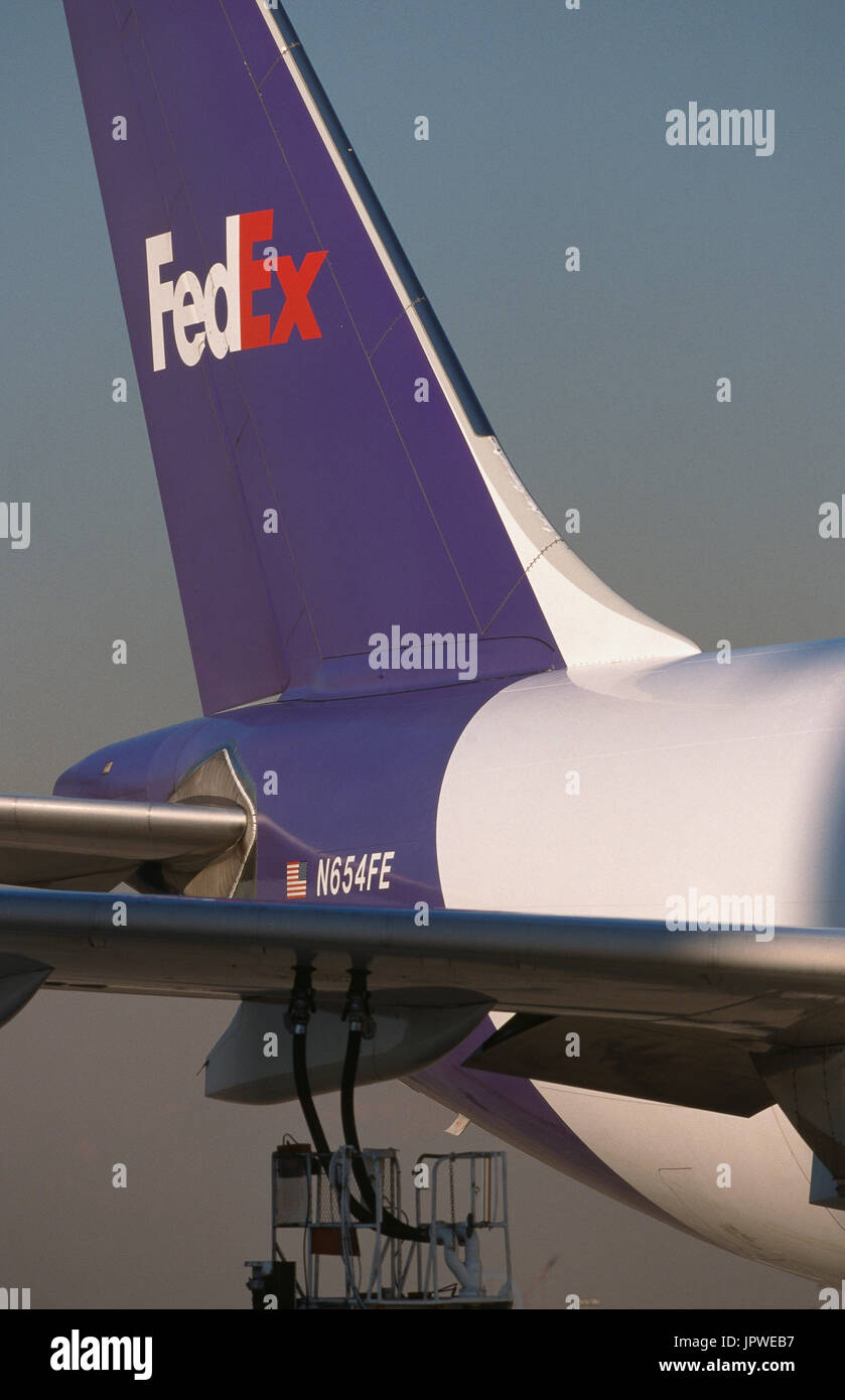 fuel hoses attached to the underside of the wing of a FedEx Airbus A300-600 freighter with tail-fin behind Stock Photo