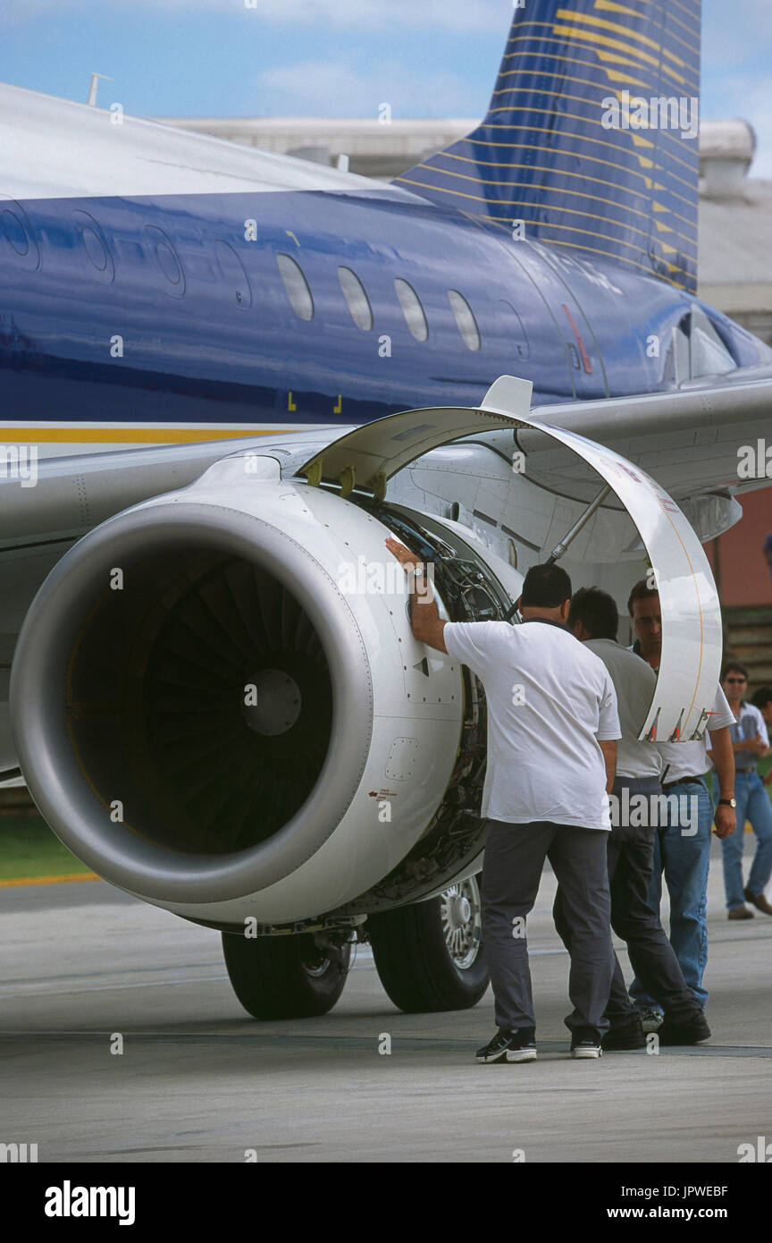 engineers inspecting inside the open CF34-8E engine cowling of prototype Embraer 170 Stock Photo