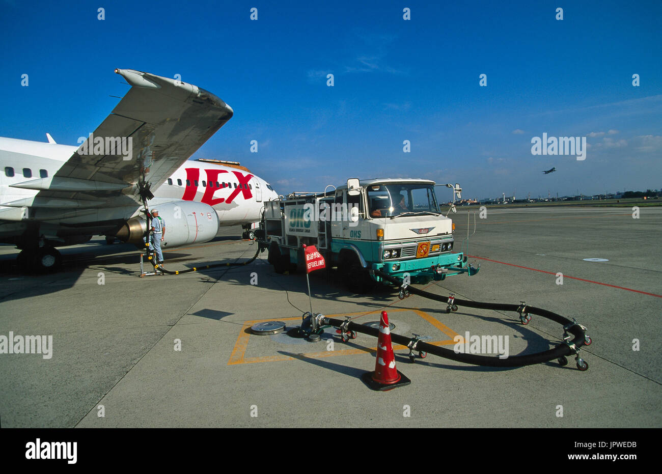 refuellers and Osaka Kokusai Shoji refuelling truck with JAL Express Boeing 737-400 parked behind Stock Photo