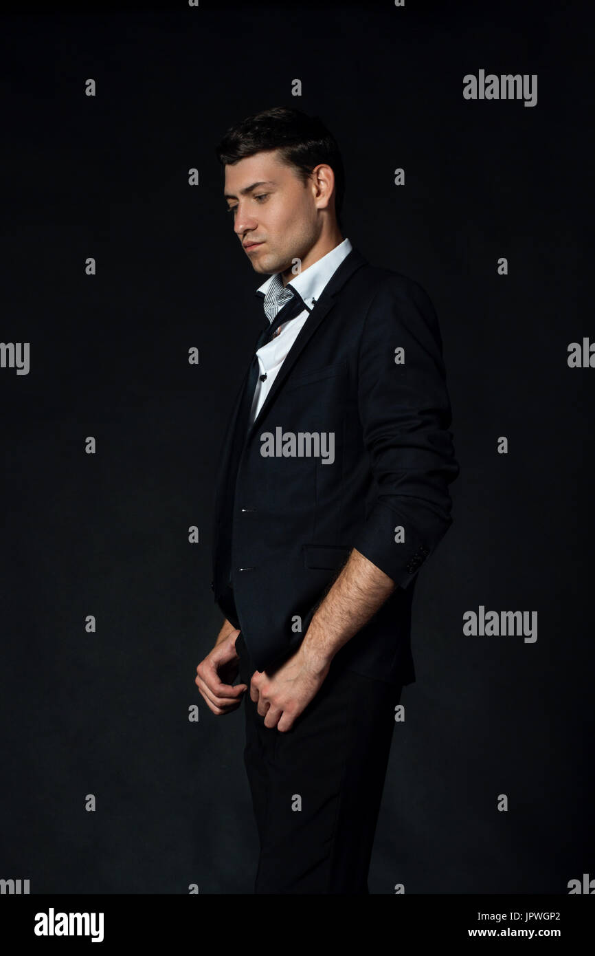 Handsome young man in suit on the black background Stock Photo - Alamy