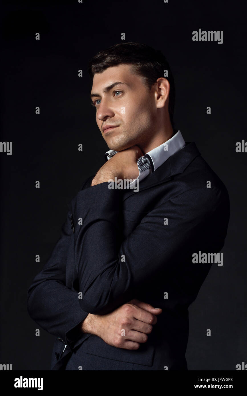 Handsome young man in suit on the black background Stock Photo - Alamy